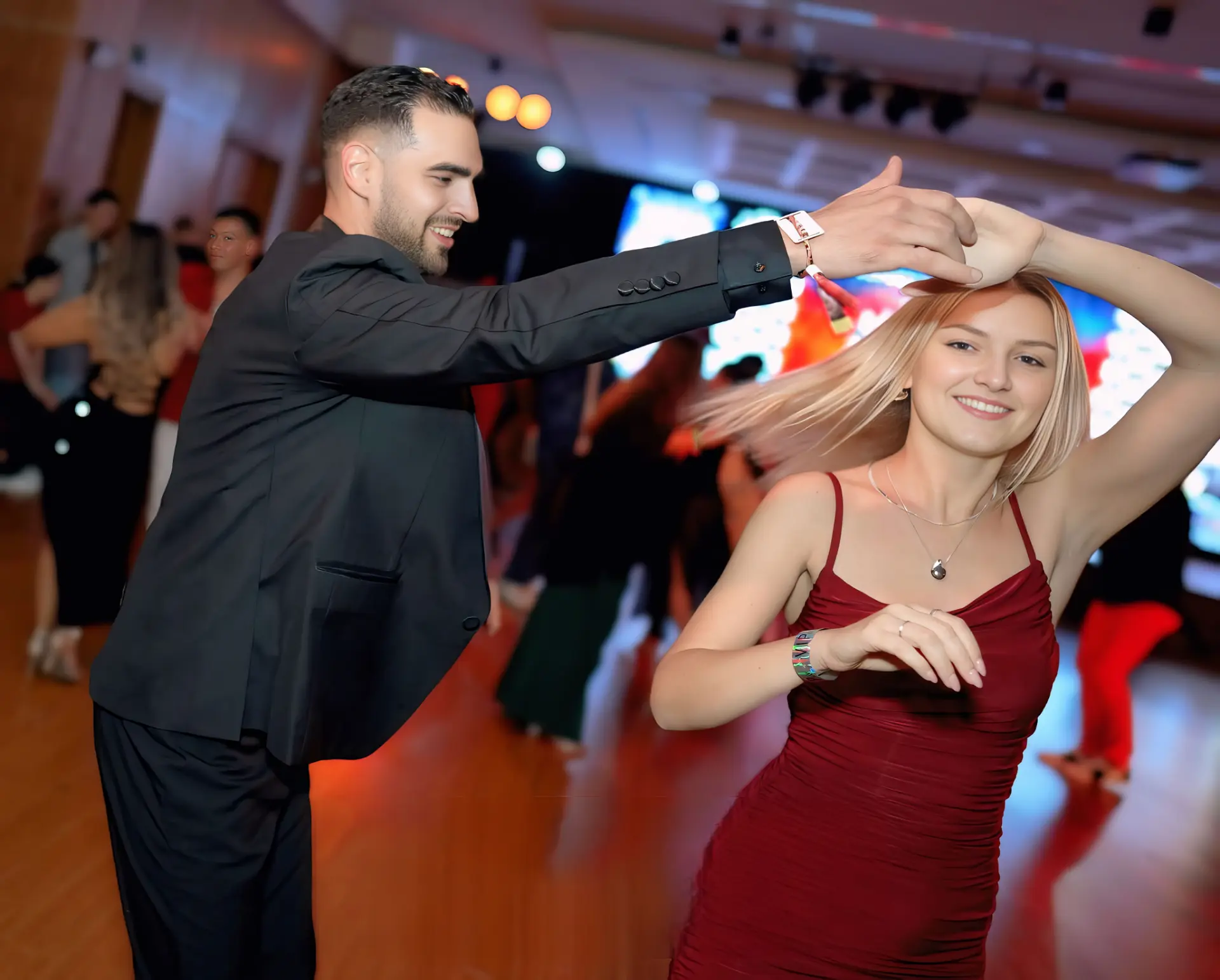 Pareja bailando salsa en un salón elegante