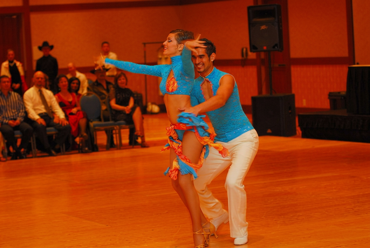 Pareja de bailarines de salsa en escenario durante una presentación de competencia